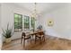 Inviting dining area with hardwood floors, stylish chandelier, and ample natural light from large windows at 8420 Bells Lake Rd, Apex, NC 27539