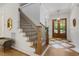 Grand foyer showcasing hardwood floors, stairs with iron railings, and beautiful wooden double doors at 8420 Bells Lake Rd, Apex, NC 27539