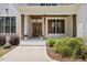 Inviting front porch featuring wood columns, a stylish door, and charming landscaping at 8420 Bells Lake Rd, Apex, NC 27539