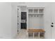 Well-organized mudroom with bench, storage cubbies, and hooks, leading to the laundry area at 8420 Bells Lake Rd, Apex, NC 27539