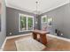 Home office with hardwood floors, a modern chandelier, and a large window offering natural light at 8420 Bells Lake Rd, Apex, NC 27539