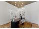 A view of the office with modern desk, neutral walls, built-in shelving, and a stylish chandelier at 8420 Bells Lake Rd, Apex, NC 27539