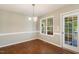 Dining room featuring wood floors, a large window, and door to a patio at 86 Basswood Cir, Willow Springs, NC 27592