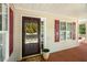 Welcoming front porch showcasing a charming entrance door, red shutters, and cozy outdoor space at 86 Basswood Cir, Willow Springs, NC 27592