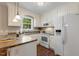 Well-lit kitchen featuring white cabinetry, modern appliances, and a window with a view at 86 Basswood Cir, Willow Springs, NC 27592