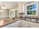 Bright kitchen with stainless steel sink, white cabinets, and granite countertops at 86 Basswood Cir, Willow Springs, NC 27592