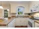 Well-lit kitchen showcasing white cabinets, a double sink, and modern appliances for cooking enjoyment at 86 Basswood Cir, Willow Springs, NC 27592