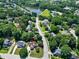 Aerial view of a neighborhood, highlighting the home's location amidst lush greenery, lake and tennis courts at 917 Haddon Hall Dr, Apex, NC 27502