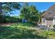 Lush backyard featuring a well-maintained lawn, mature trees, shed and a cozy patio area at 917 Haddon Hall Dr, Apex, NC 27502