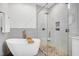 Stunning bathroom featuring a soaking tub and glass shower stall with gray stone tiling at 917 Haddon Hall Dr, Apex, NC 27502