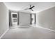 Large bedroom with neutral carpet and paint, two windows, and a ceiling fan with light at 917 Haddon Hall Dr, Apex, NC 27502