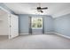 Spacious bedroom features a ceiling fan, light blue walls, and a window with backyard views at 917 Haddon Hall Dr, Apex, NC 27502