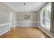 Neutral dining room featuring hardwood floors, chair railing and a large bright window at 917 Haddon Hall Dr, Apex, NC 27502