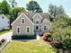 Classic tan home with well-manicured lawn, trim landscaping, and mature shade trees at 917 Haddon Hall Dr, Apex, NC 27502