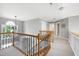 Hallway featuring a decorative railing, neutral walls and flooring, and lots of natural light from a large window at 917 Haddon Hall Dr, Apex, NC 27502