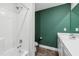 Modern bathroom featuring a shower and vanity with green accent wall at 933 Weatherby Ln, Creedmoor, NC 27522