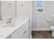 Bathroom featuring tile floor, white cabinets, sink, toilet, and window at 933 Weatherby Ln, Creedmoor, NC 27522
