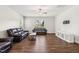 Spacious living room featuring hardwood floors, ceiling fan, and comfortable leather seating at 933 Weatherby Ln, Creedmoor, NC 27522
