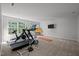 Spacious basement with carpet floors, a TV, workout equipment, and natural light at 100 Redfoot Run Rd, Chapel Hill, NC 27516