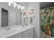 Bathroom featuring a double vanity, mirror, and a shower with tropical-themed curtain at 100 Redfoot Run Rd, Chapel Hill, NC 27516