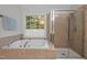 Luxurious bathroom featuring a soaking tub, glass shower, and neutral tile at 100 Redfoot Run Rd, Chapel Hill, NC 27516