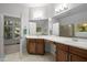 Spacious bathroom with dual sinks, wooden cabinets, and an abundance of natural light at 100 Redfoot Run Rd, Chapel Hill, NC 27516