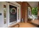Inviting front porch area with decorative wreath on door and rocking chair seating at 100 Redfoot Run Rd, Chapel Hill, NC 27516