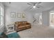Bright living room with a ceiling fan, a couch, and decor, leading to a staircase at 100 Redfoot Run Rd, Chapel Hill, NC 27516