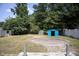 A large backyard with a shed and trees is enclosed with a white fence at 103 Sara Dr, Nashville, NC 27856