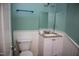 Cozy bathroom with white vanity, tan countertop, beadboard paneling and blue-green walls at 103 Sara Dr, Nashville, NC 27856
