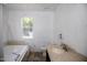 Bathroom features a garden tub, elongated toilet, and a single sink vanity with a large window at 103 Sara Dr, Nashville, NC 27856