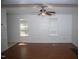 Bright living room features hardwood floors, a ceiling fan, and white walls with large windows allowing natural light at 103 Sara Dr, Nashville, NC 27856