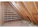 This attic features a finished room with wooden shelves for storage and exposed beams at 105 Greenbriar Ct, Chapel Hill, NC 27516