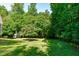 Lush backyard with a small outbuilding nestled among the trees, offering a serene and private outdoor space at 105 Greenbriar Ct, Chapel Hill, NC 27516