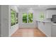 Bright dining area with hardwood floors, white trim, and large windows offering serene views of the surrounding greenery at 105 Greenbriar Ct, Chapel Hill, NC 27516