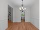 Formal dining room with beautiful chandelier, hardwood floors, and wainscoting, perfect for hosting gatherings at 105 Greenbriar Ct, Chapel Hill, NC 27516