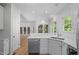 Elegant kitchen featuring white cabinetry, stainless steel appliances, and a breakfast bar with views to the outdoors at 105 Greenbriar Ct, Chapel Hill, NC 27516