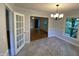 Light filled dining room with tile floor and chandelier, offering a view of the front room and lovely yard at 108 Shadowbrook Dr, Hillsborough, NC 27278