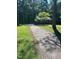 Driveway leading to a home surrounded by grass and tall trees at 108 Shadowbrook Dr, Hillsborough, NC 27278