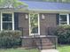 Close-up of brick home's front entrance with charming black shutters and a welcoming brick staircase at 108 Shadowbrook Dr, Hillsborough, NC 27278