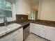Well-lit kitchen featuring a double sink, white cabinets, stainless steel appliances, and tile countertops at 108 Shadowbrook Dr, Hillsborough, NC 27278