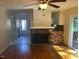 Open living room with hardwood floors, brick fireplace, ceiling fan, and sliding glass doors to backyard at 108 Shadowbrook Dr, Hillsborough, NC 27278
