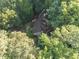 An aerial view shows the home nestled in the trees with lush green foliage at 10836 Wilmore Dr, Raleigh, NC 27614