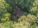 An aerial view shows the roof of the house peeking through a dense forest at 10836 Wilmore Dr, Raleigh, NC 27614