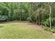Lush green backyard with mature trees and landscaping, creating a peaceful outdoor retreat at 10836 Wilmore Dr, Raleigh, NC 27614