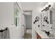 Hallway bathroom features a modern vanity, updated lighting, and window with blind at 10836 Wilmore Dr, Raleigh, NC 27614