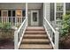 Charming front porch with brick steps and elegant white railings and accents at 10836 Wilmore Dr, Raleigh, NC 27614
