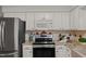 Modern kitchen with stainless steel appliances, white cabinets, and granite countertops at 10836 Wilmore Dr, Raleigh, NC 27614