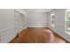 Bright living room boasts hardwood floors, large windows, and glass panel french doors at 10836 Wilmore Dr, Raleigh, NC 27614