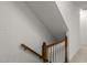 View of a staircase with white risers and dark wood handrail at 10836 Wilmore Dr, Raleigh, NC 27614